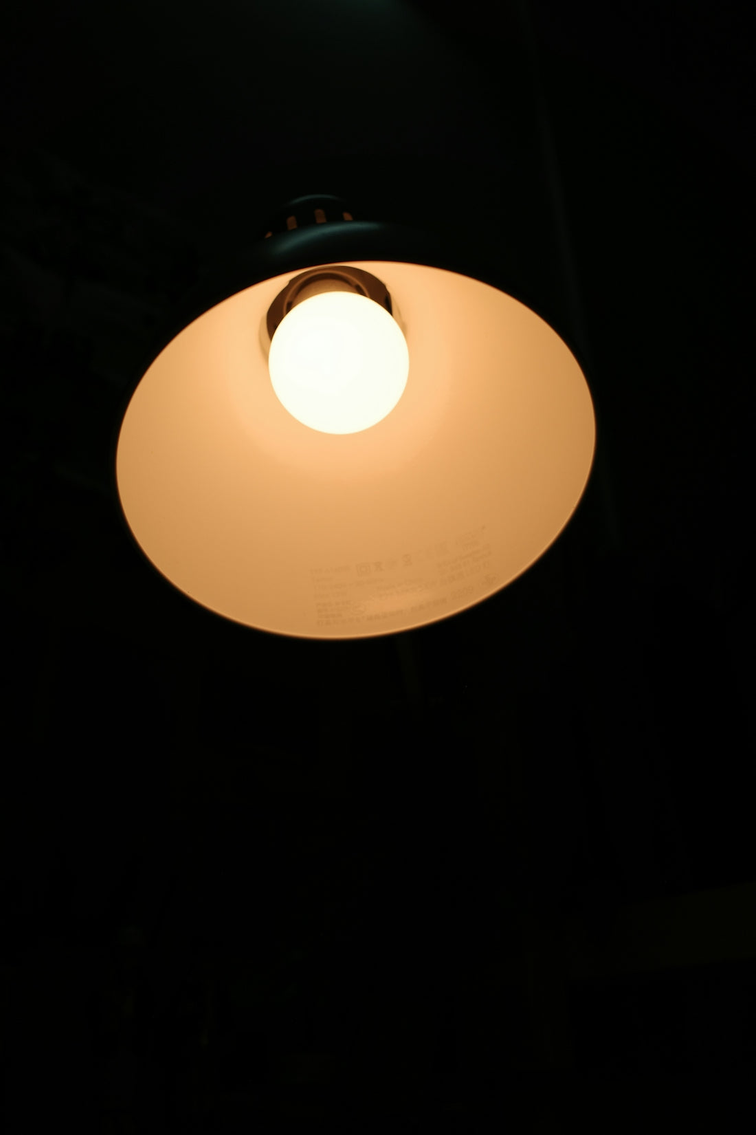 A white light hanging from a ceiling in a dark room